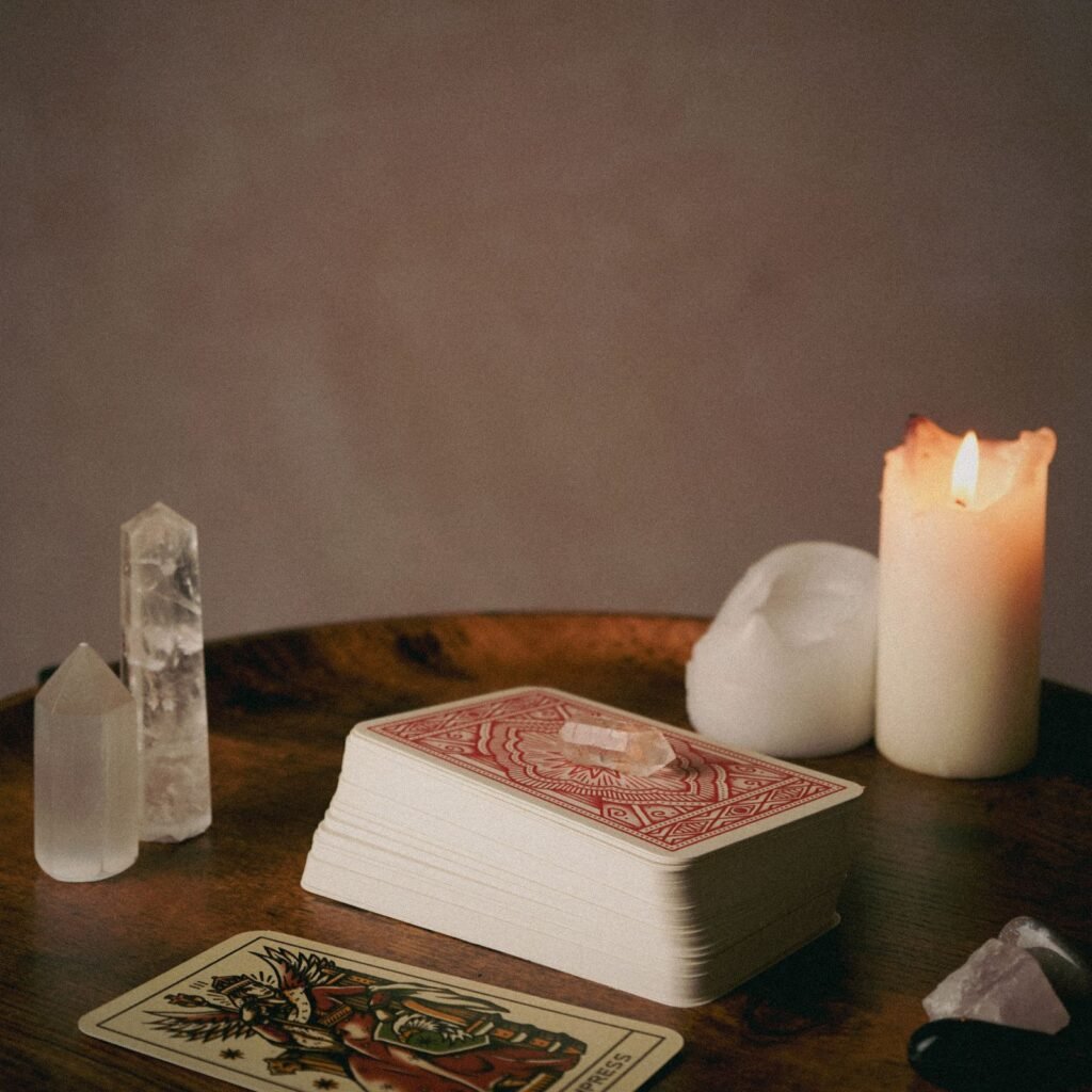 Tarot, cristais e vela sobre mesa de madeira